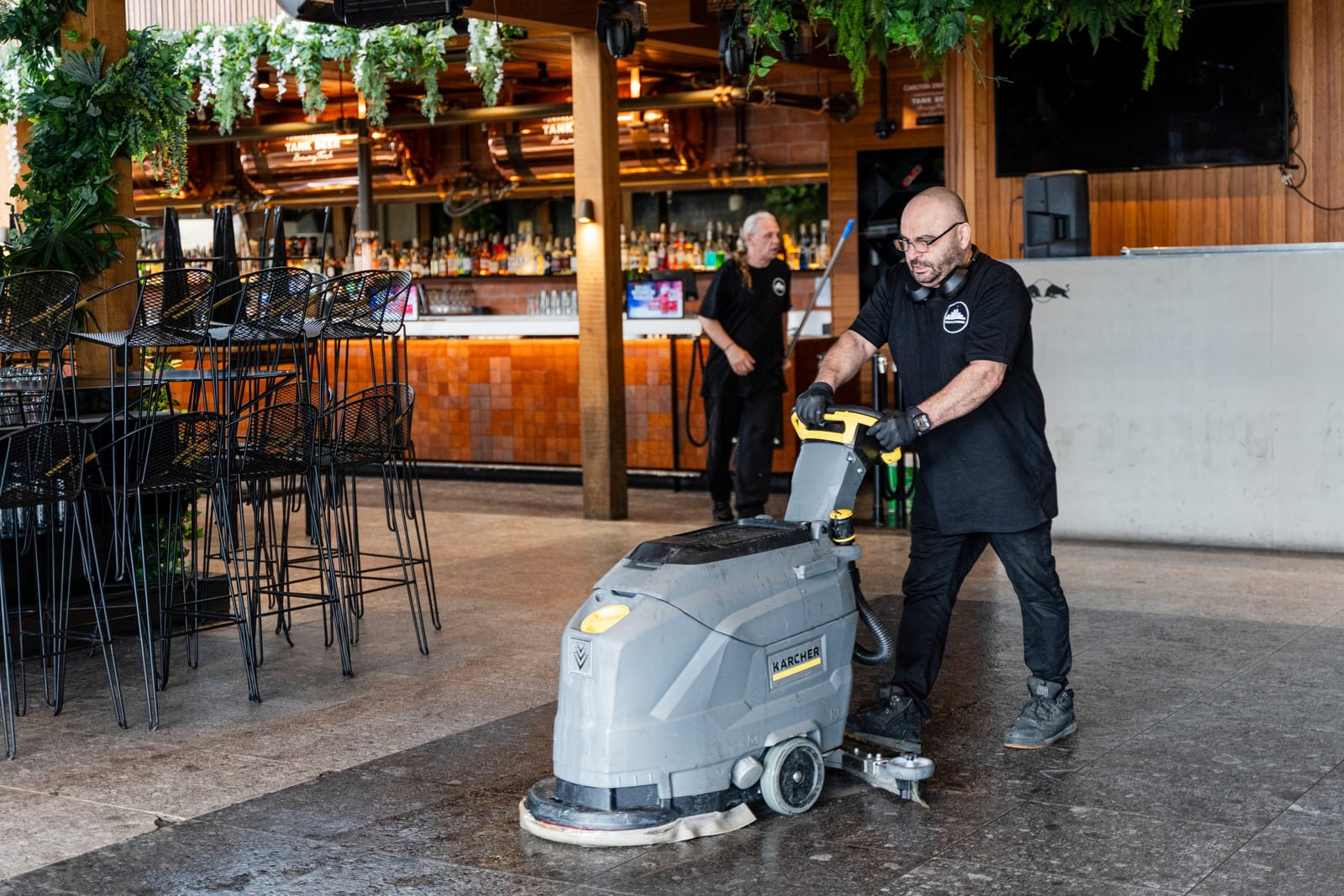 Two HOZ CLEANING cleaners scrubbing the floor of a Melbourne hospitality venue before opening.